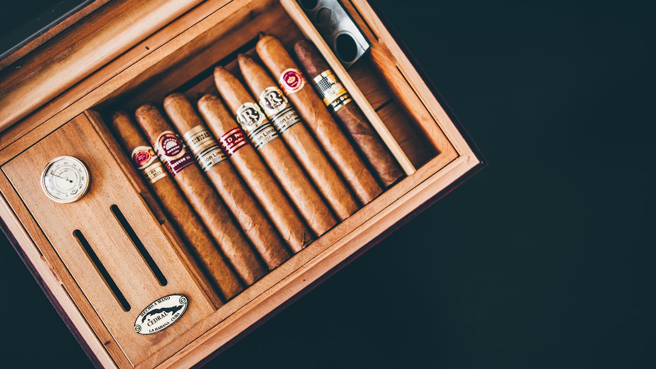 heros-img Close-up of premium Cuban cigars in a wooden humidor box, showcasing luxury and craftsmanship.